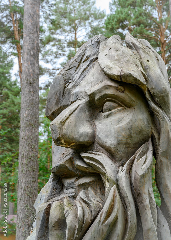 Obraz premium KEMEROVO, RUSSIA - AUGUST 19, 2022: A fragment of a wooden sculpture of a forest deity in the Siberian forest