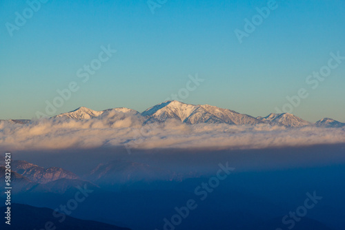 snow capped mountains peaking over the clouds in Angeles National Forest outside of Los Angeles, California.