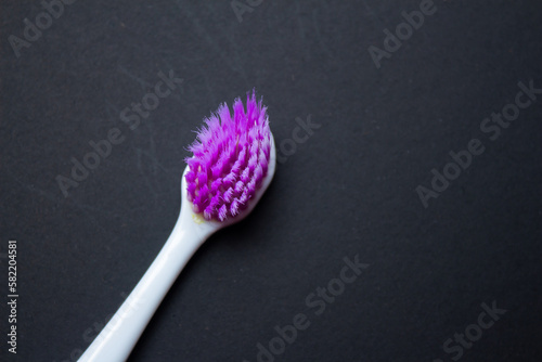 Used old purple toothbrush isolated on a black background. Top view  copy space for text.