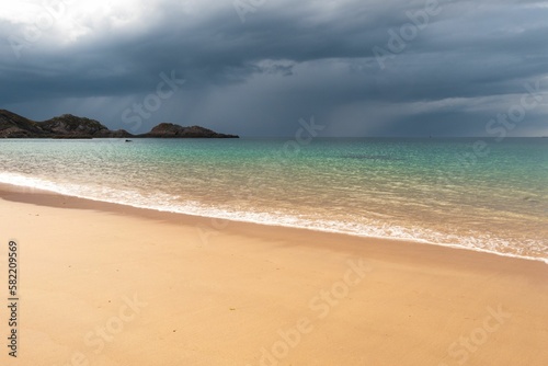 Fototapeta Naklejka Na Ścianę i Meble -  Sea waves splashing over the shore with stormy clouds in the background