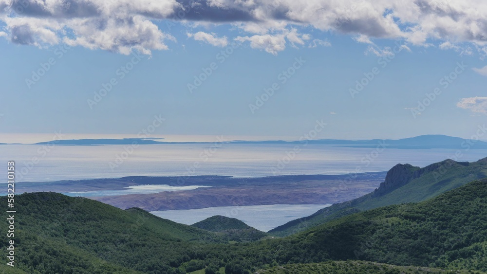 Aerial view of mountain slopes with trees before a seascape in  Croatia