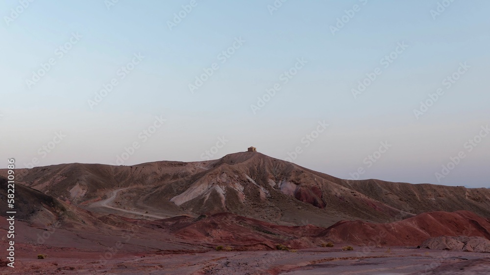 Fototapeta premium Distant view of a hill with sunset in the background