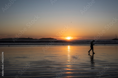 Man walking at sunset on the beach © Simona Pezzi