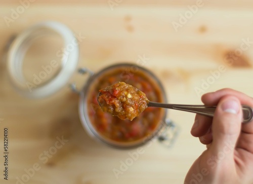 Vegetable squash sauce in a glass jar on a wooden background.