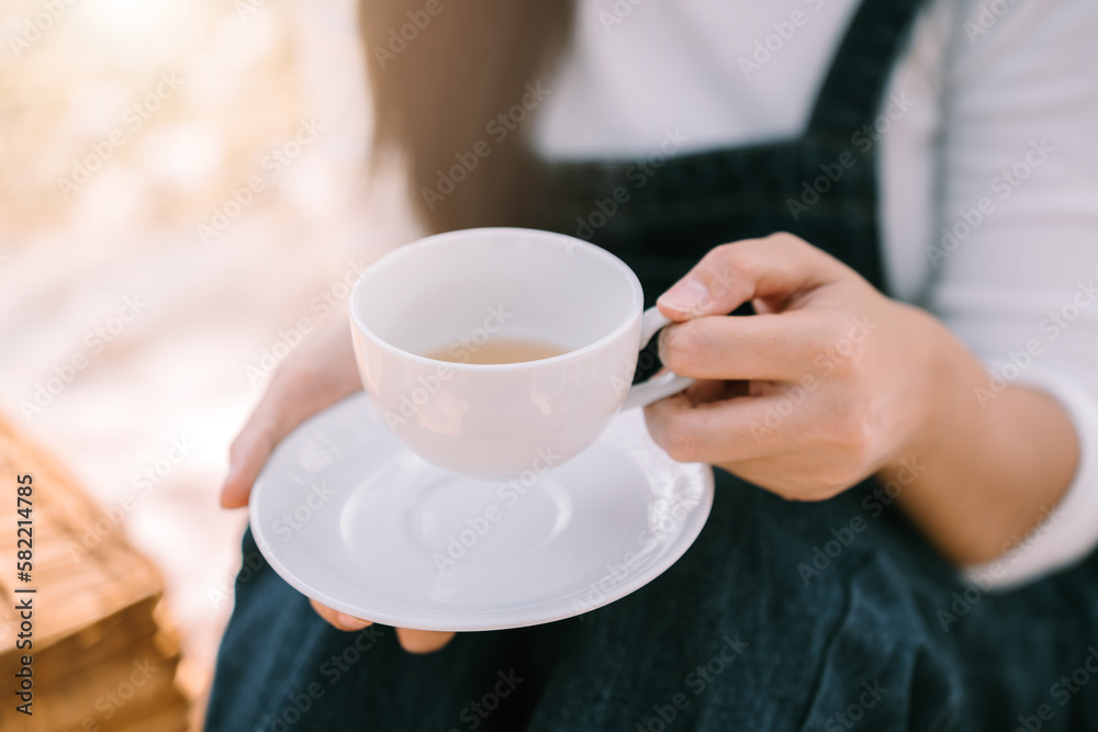 Afternoon tea in the garden, Close up hand of woman pouring tea , Relaxation and lifestyle concept.