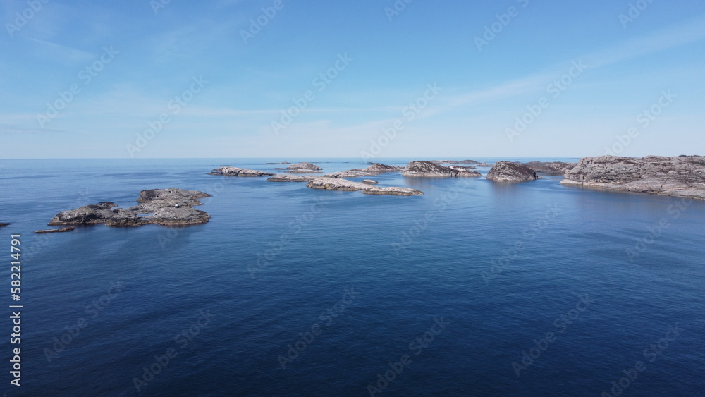 Norwegian Sea. Rocks near the sea coast. Beautiful sea water. Blue sky and nice sun rays