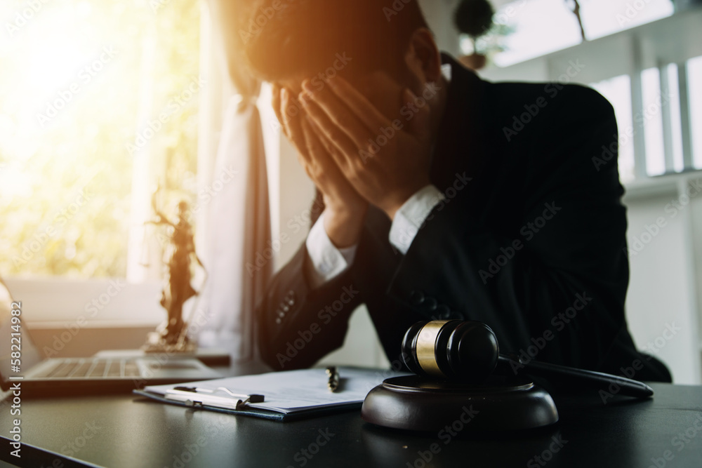 Justice and Law concept. Legal counsel presents to the client a signed contract with gavel and legal law or legal having team meeting at law firm in background