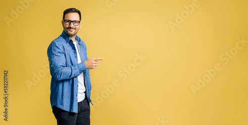 Portrait of smiling charming young adult businessman wearing denim shirt and eye Fototapeta