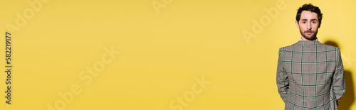 Brunette model wearing jacket backwards on yellow background, banner. photo