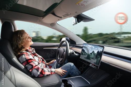 Woman resting while her car is driven by an autopilot. Self driving vehicle concept	