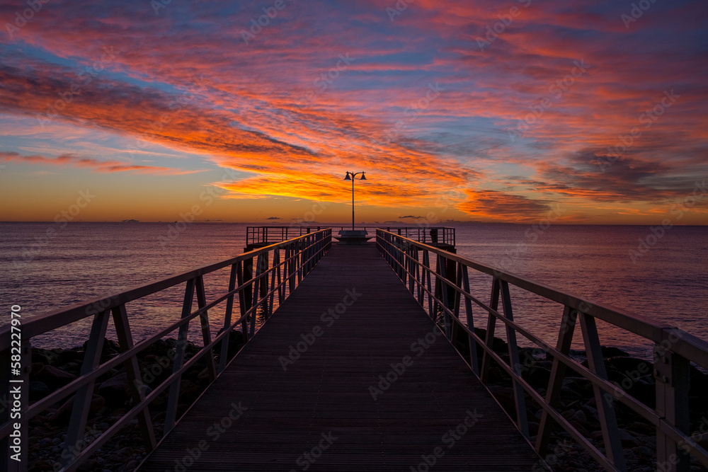 
silhouette of a jetty on the sea at sunrise in the mediterranean sea