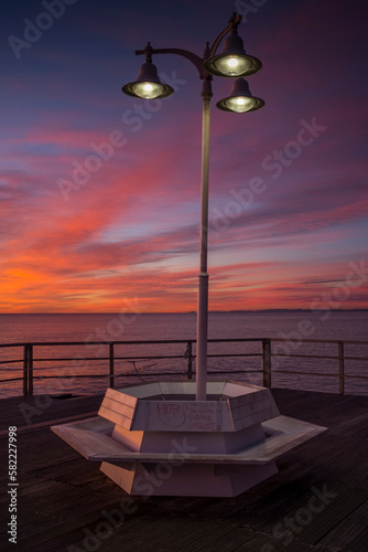 
bench on a walkway in the sea at sunrise