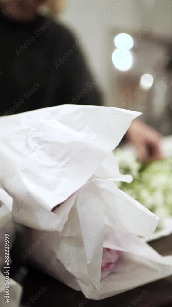 Awesome florist girl working in flower shop, preparing flowers for sale, vertical video Awesome florist girl working in flower shop, preparing flowers for sale, vertical video