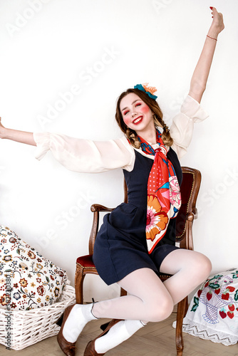 Fashionable beautiful brunette girl in a dress with floral embroidery with color makeup: red cheeks and lips. Granny chic style. Retouched portrait photo