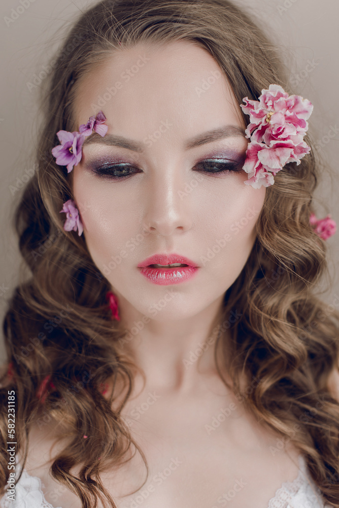 Cosmetics and manicure. Close-up portrait of attractive woman with dry flowers on her face and hair, pastel color, perfect make-up and skin on blue background. Fresh, trendy, spring retouched portrait Cosmetics and manicure. Close-up portrait of attractive woman with dry flowers on her face and hair, pastel color, perfect make-up and skin on blue background. Fresh, trendy, spring retouched portrait
