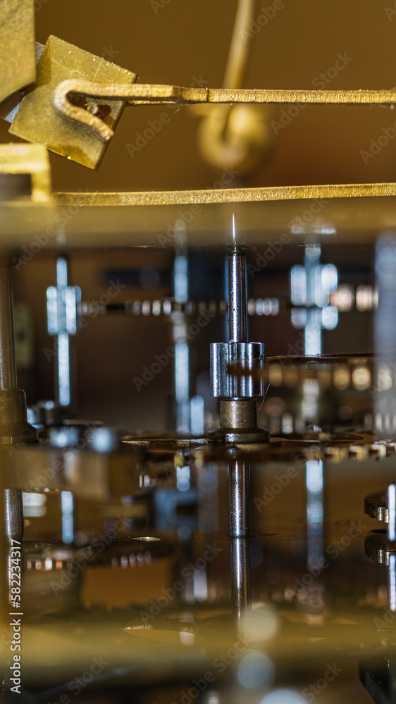 The mechanism of an old watch. clock mechanism made in the technique of toning. Focus on the central gears. Very shallow depth of field