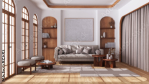 Blurred background, modern wooden living room with parquet and arched windows. Fabric sofa, carpets and armchairs. Boho style interior design