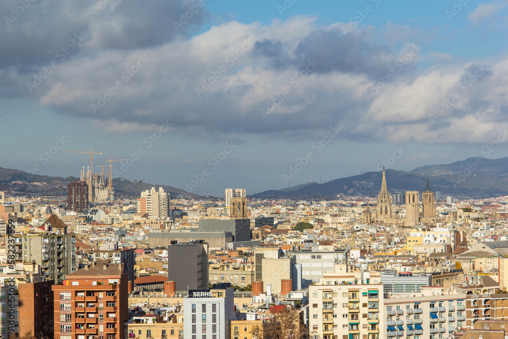 A statue looks over the city of Barcelona with Sagrada Familia towering in the background.
