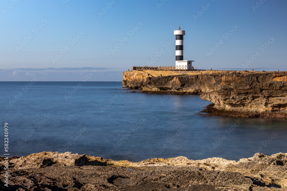 Black and white striped lighthouse of Colonia de Sant Jordi on a rocky headland, Majorca, Mallorca, Balearic Islands, Spain, Europe