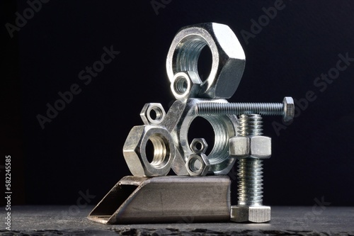 composition of nuts bolts and scraps of metal laid out on a dark background.