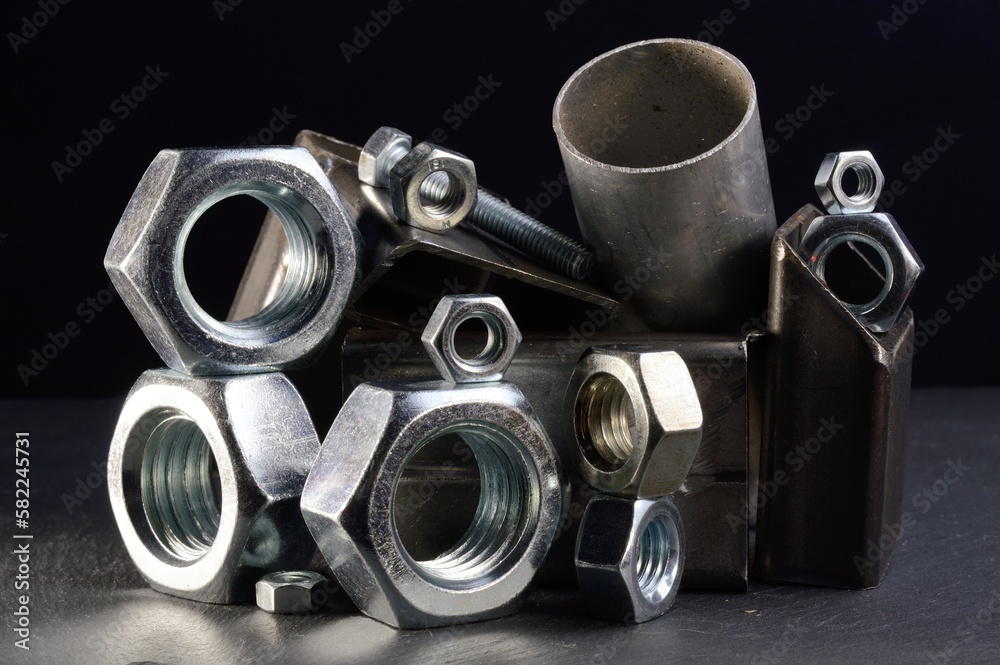 composition of nuts bolts and scraps of metal laid out on a dark background. composition of nuts bolts and scraps of metal laid out on a dark background.