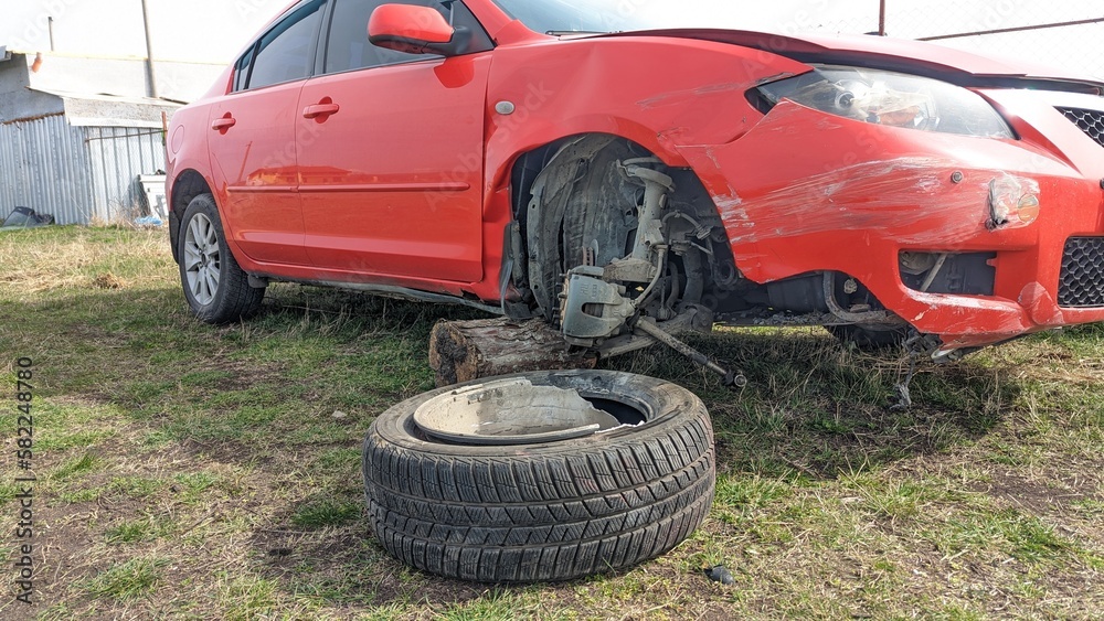 A car after a traffic accident, a broken headlight, a torn wheel, a broken car wing A car after a traffic accident, a broken headlight, a torn wheel, a broken car wing
