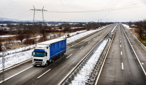 Highway transportation with large Lorry truck passing trucks in a snowy winter landscape