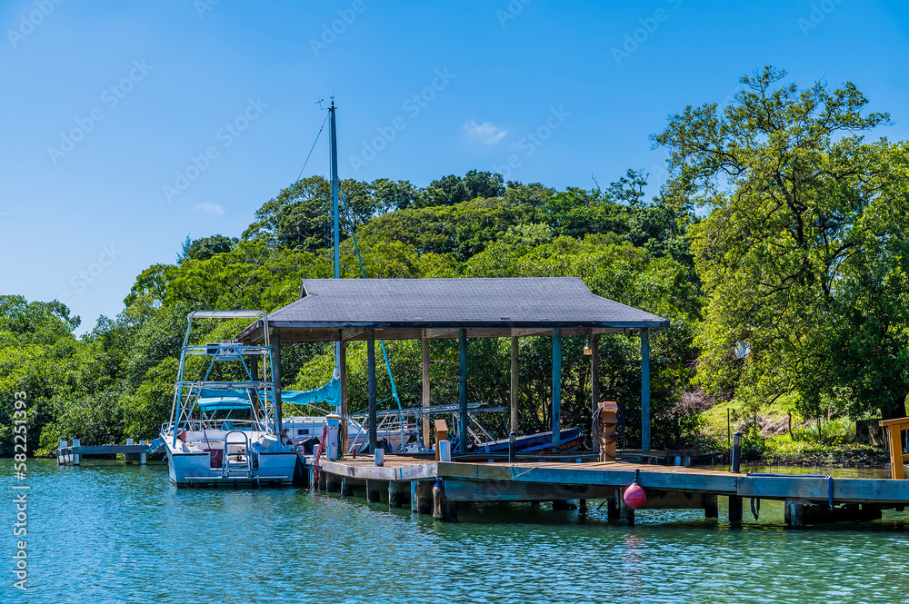 A view of a jetty and boats in a cove next to West Bay on Roatan Island on a sunny day