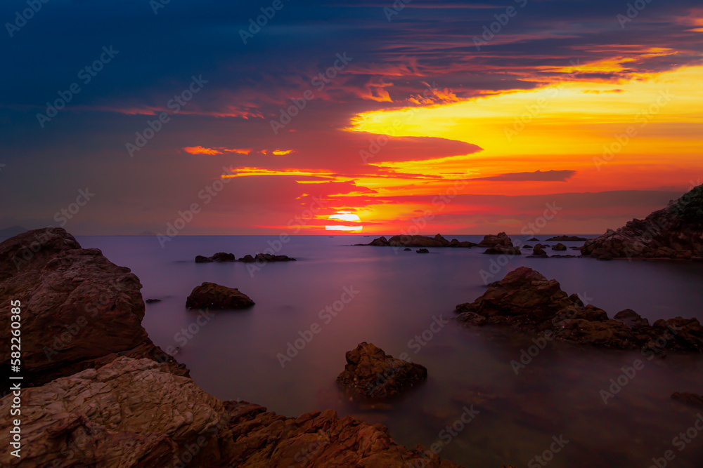 Sea and rock scenery in the evening,Landscape Long exposure of majestic clouds in the sky sunset or sunrise over sea with reflection in the tropical sea.