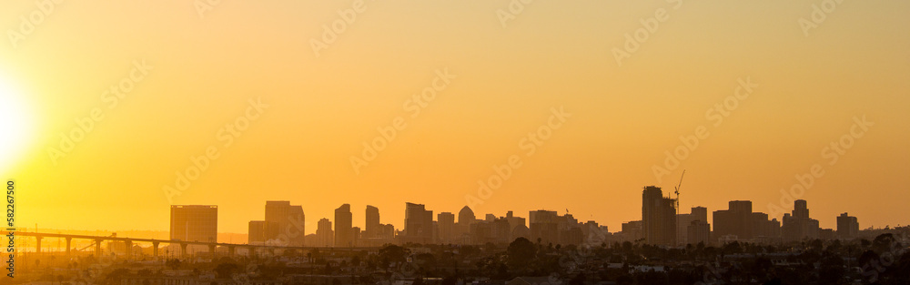 Sunsetting over the pacific ocean with the San Diego skyline and bridge to Coronado in silhouette.