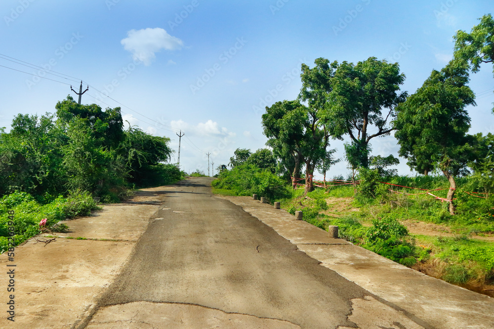 Beautiful view and road at gir forest in gujarat. the rural area road in jungle. This Photo captured in Indian small village and rural areas in Gujarat India. horizontal road, farm land