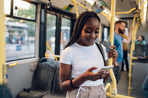 African american woman riding in a bus and using a smartphone photo