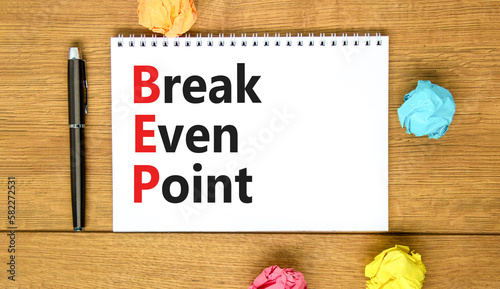 BEP break even point symbol. Concept words BEP break even point on white note on a beautiful wooden table wooden background. Pen. Business and BEP break even point concept. Copy space. © Dzmitry
