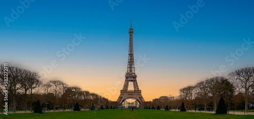 The Eiffel Tower over the green lawn field of Champ de Mars, Field of Mars, in Paris, France © Naya Na