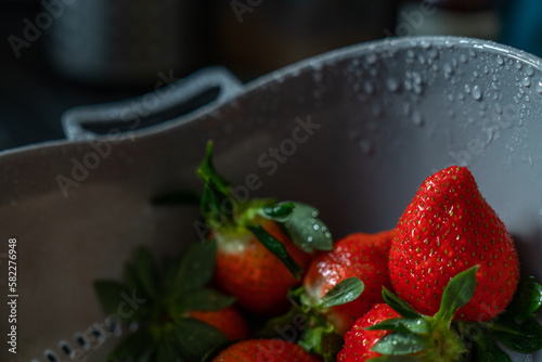 Freshly washed strawberries in a colander with drops of water photo