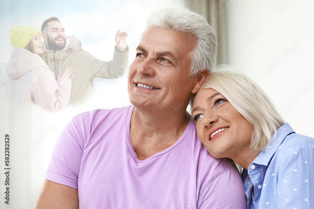 Happy senior couple remembering old times. Translucent picture of young couple showing them in their youth Happy senior couple remembering old times. Translucent picture of young couple showing them in their youth