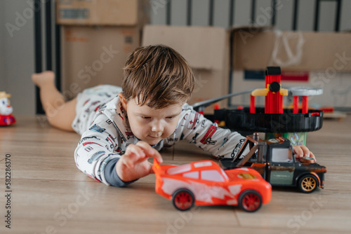 Happy kid playing with old car toy at home