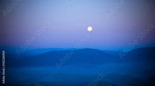 The moon, between the mountains on a summer night