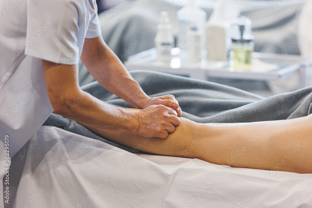 Obraz premium Professional calf and leg massage by massage therapist. Spa well being self care of body concept