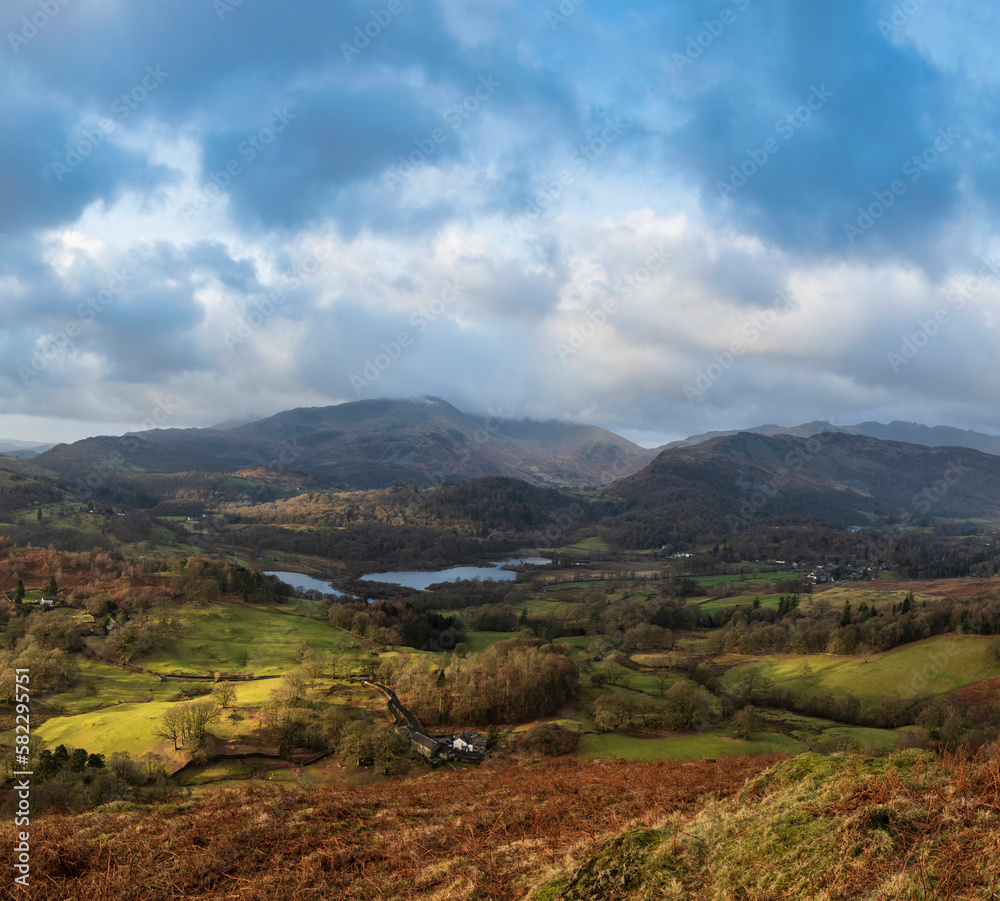 Stunning Winter sunrise golden hour landscape view from Loughrigg Fell across the countryside towards Langdale Pikes in the Lake District