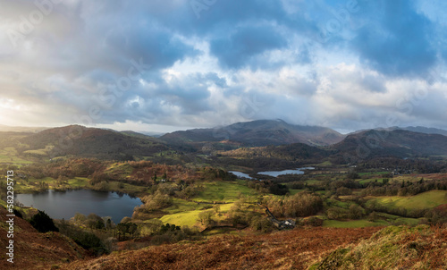 Stunning Winter sunrise golden hour landscape view from Loughrigg Fell across the countryside towards Langdale Pikes in the Lake District