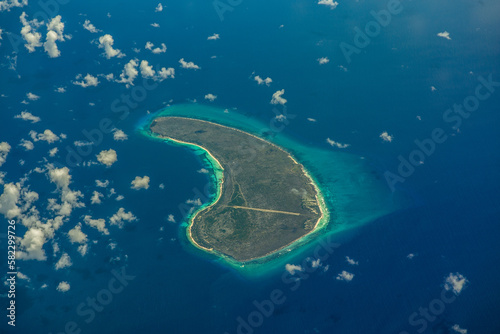 Aerial landscape view of isolated Assomption Island, Seychelles, located in the most southwestern part of Seychelles, part of Aldabra Group, with Assomption Airport and its runway crossing the Island