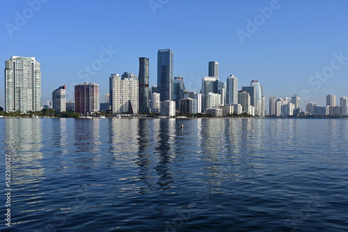 Miami, Florida skyline reflected on calm Biscayne Bay in morning light on sunny clear day. © Francisco