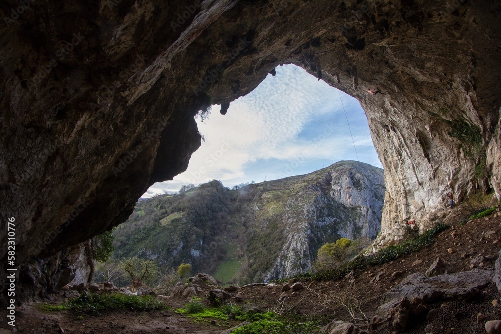 athlete tries to overcome a difficult climbing step in an overhang In a cave in Asturias