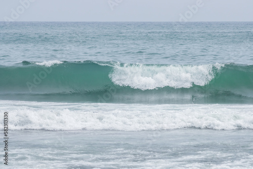 Seascape. View of the waves and surf. Windy weather. Waves, foam and ripples on the surface of sea water. Summer landscape. The expanses of the Pacific Ocean. Beautiful natural background. Nobody.