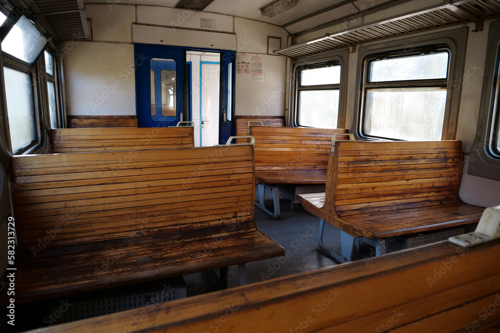 Naklejka premium Old empty wagon of train. Wooden seats in an empty coach of train