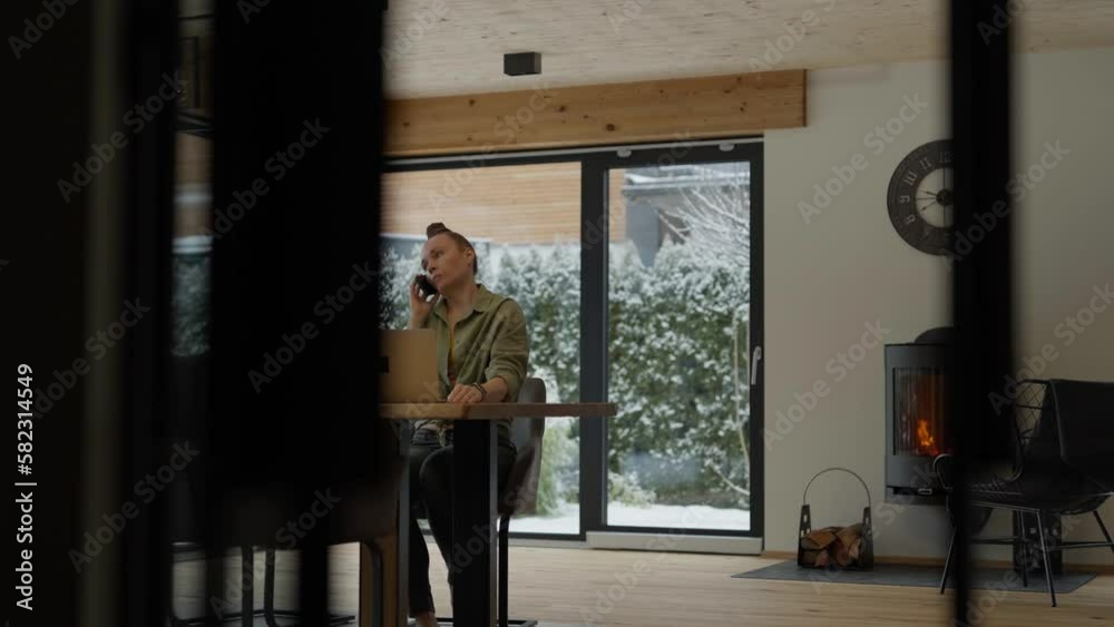 Young female is speaking on phone sitting at the table. Young female is speaking on phone sitting at the table.