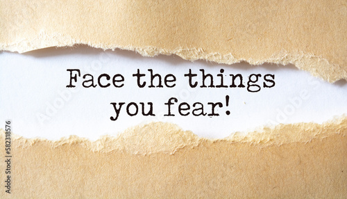 Face the things you fear. Words written under torn paper. Motivation concept text.