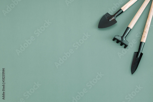 Three garden tools on a green background.