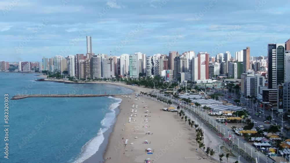 Beira Mar de Fortaleza. Fortaleza city,  Brazil. Flying towards beach with Hotels and Resorts Backdrop beach drone footage. Skyline of Fortaleza city from ocean, Ceara State, Brazil